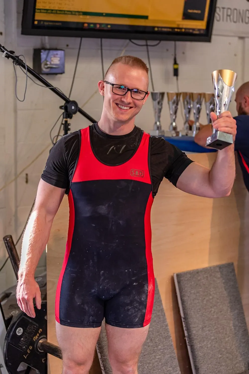 Andrew smiling and holding up his first-place trophy