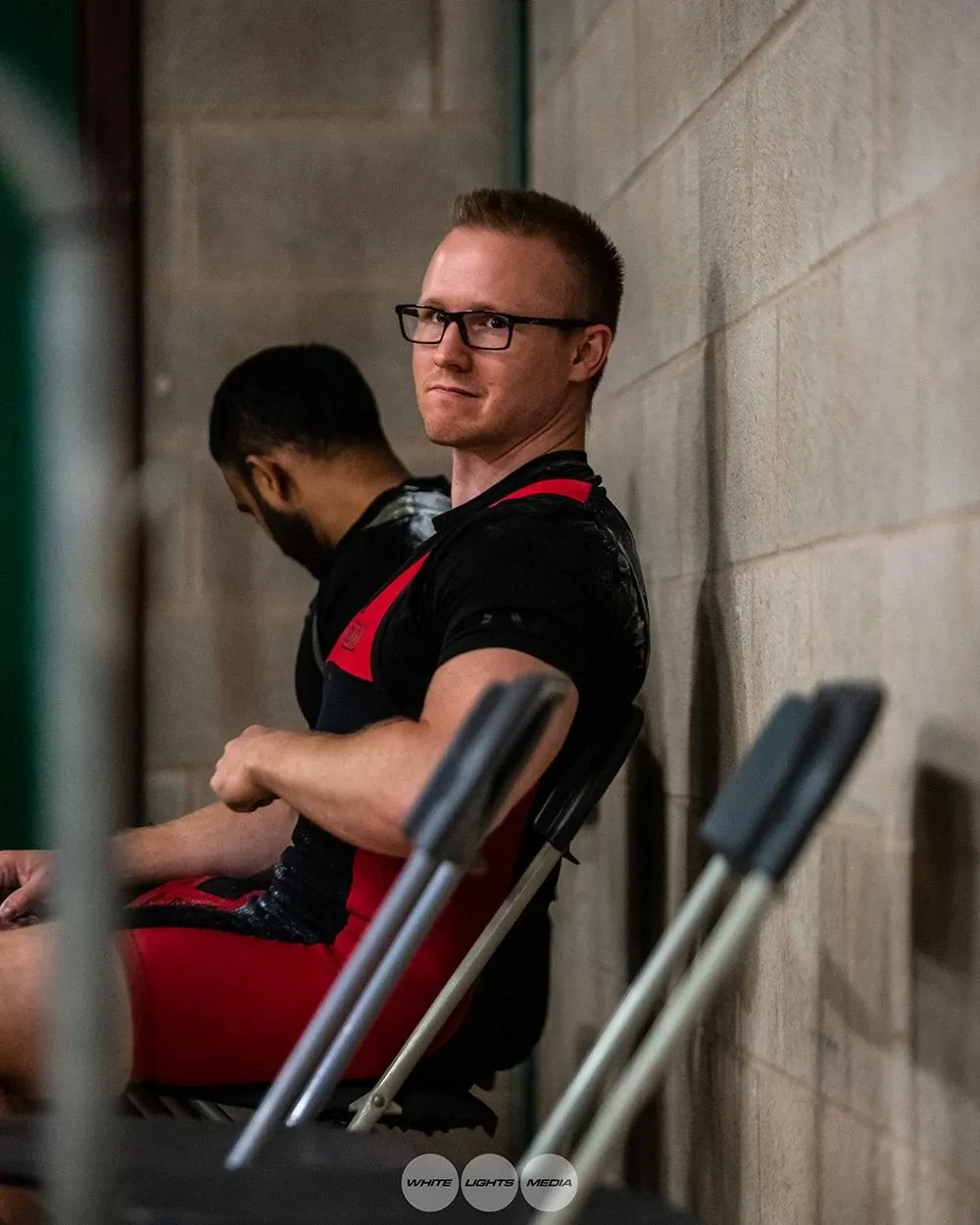 Andrew sitting quietly against the wall in the warm-up area as the nerves start to kick in