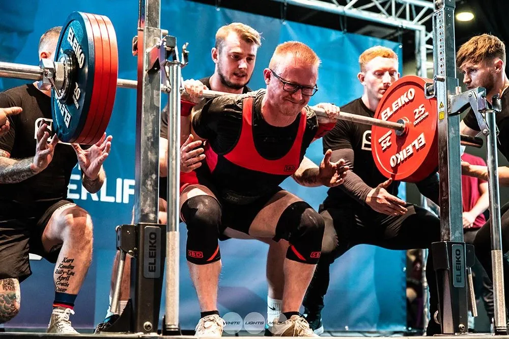 Andrew driving up out of the 222.5 kg squat, nearly at the top