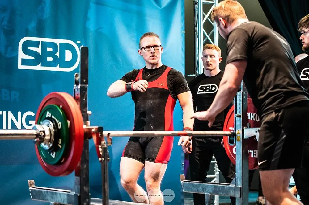Andrew on the platform explaining how he wants the middle hand-out on the bench press