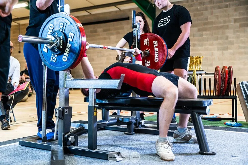 Andrew on the bench with 170 kg loaded on the bar and spotters standing by