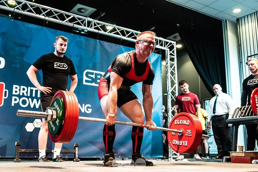 The 245 kg deadlift moving up past Andrew’s knees