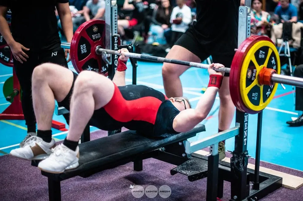 Andrew arched on the bench, setting up to lift 155 kg