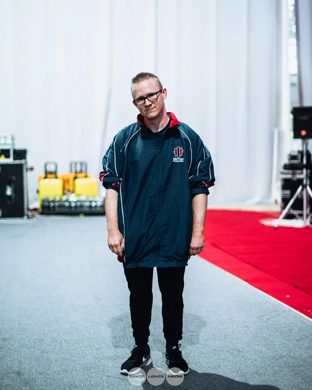 Andrew standing in the oversized GBR team jacket, sleeves hanging past his hands