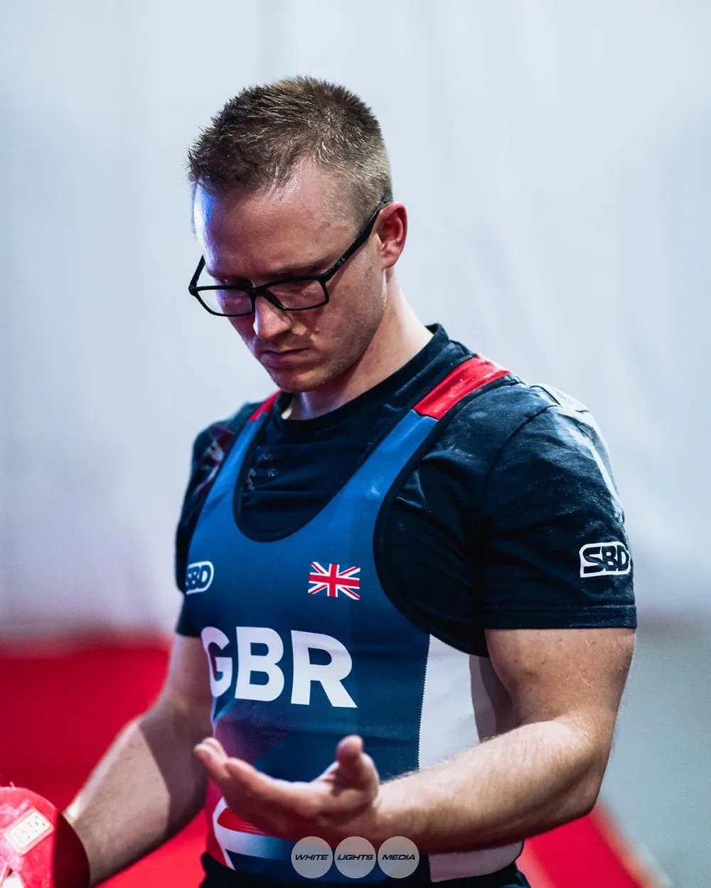 Andrew in his Team GBR singlet looking down as he chalks his hands