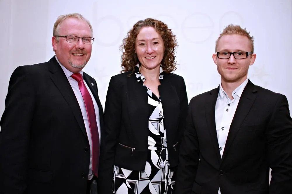 Andrew with his fellow bseen award judges, a man and a woman, in front of the bseen backdrop