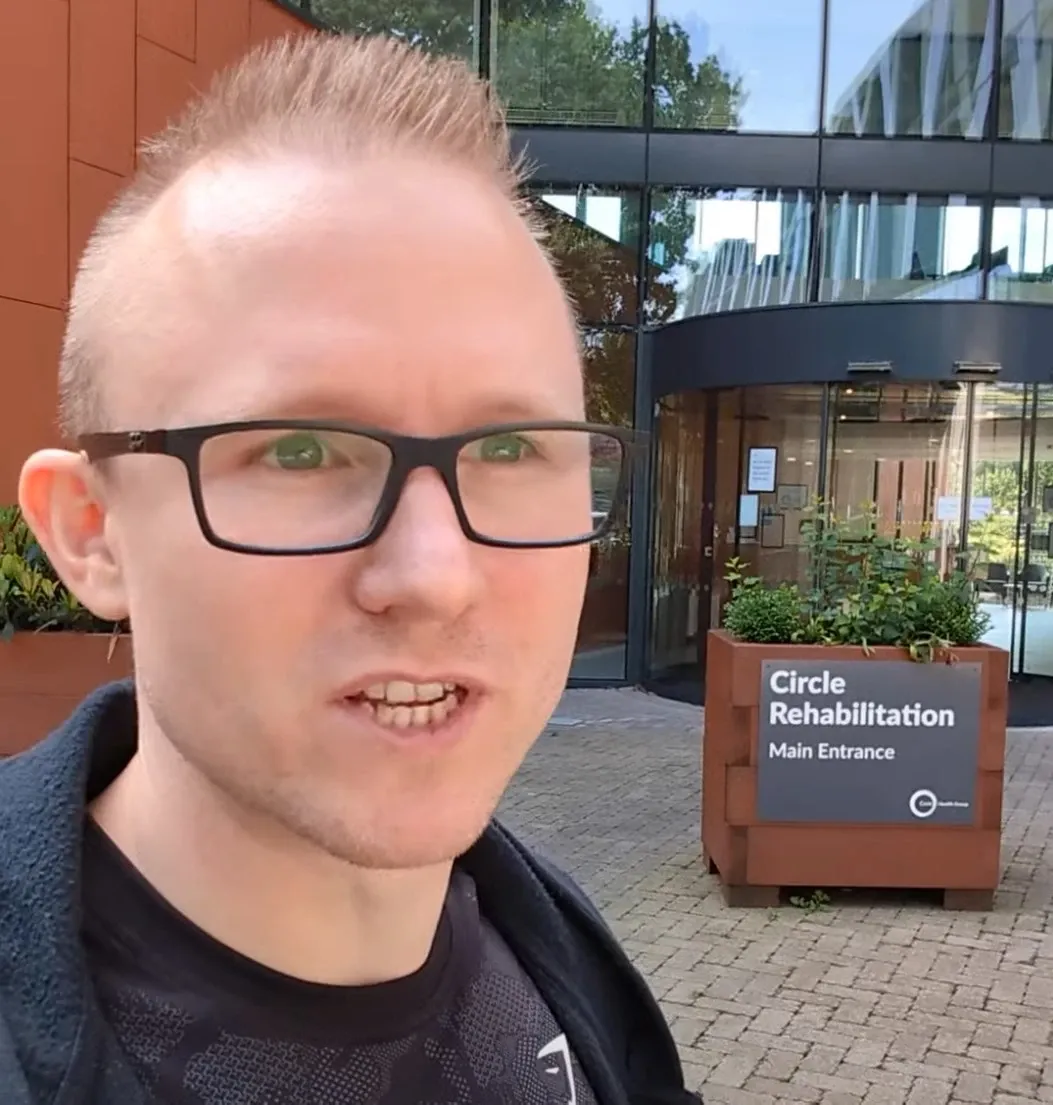 Selfie of Andrew outside the main entrance of the Circle Rehabilitation centre