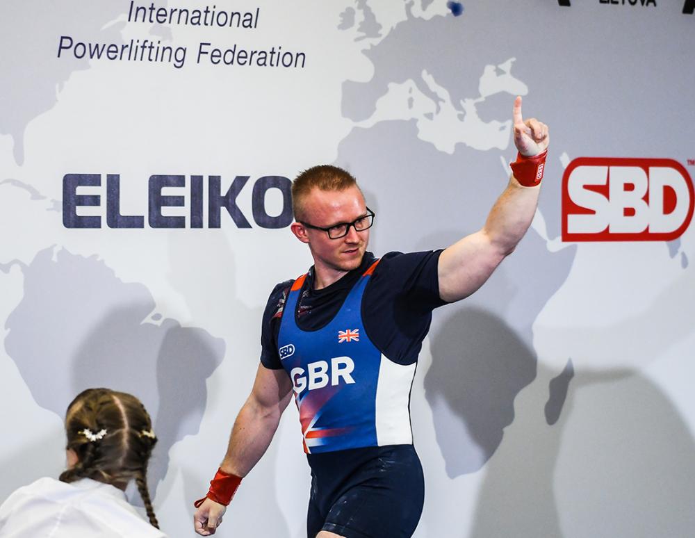 Andrew Ward Celebrating getting three good lifts, a smile on his face and a finger in the air wearing the GBR team kit